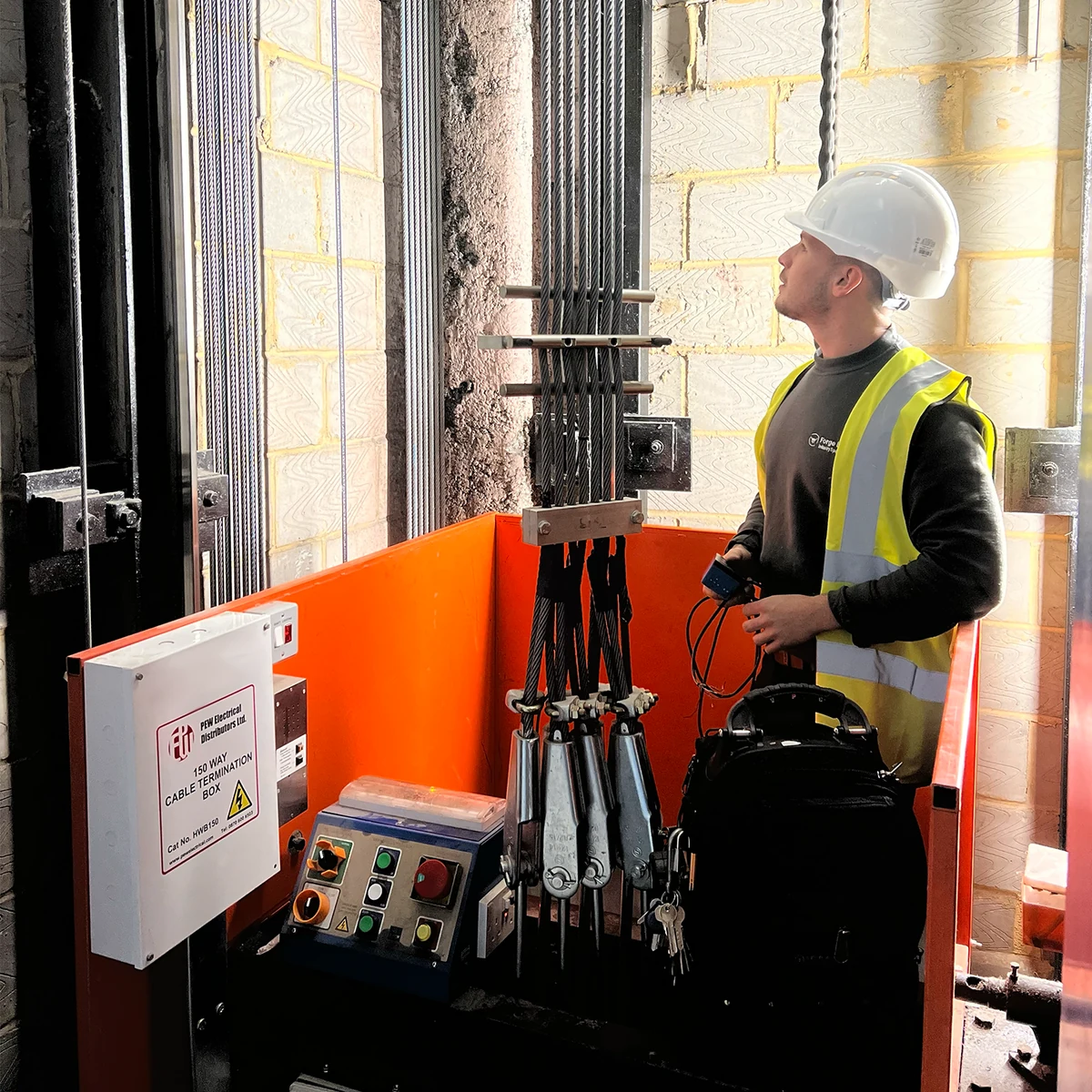 Forge Lifts engineer examining lift equipment