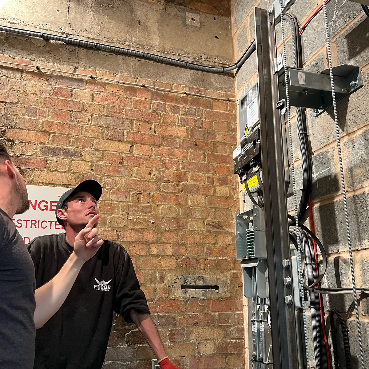 Forge Lifts engineers examining lift equipment on site