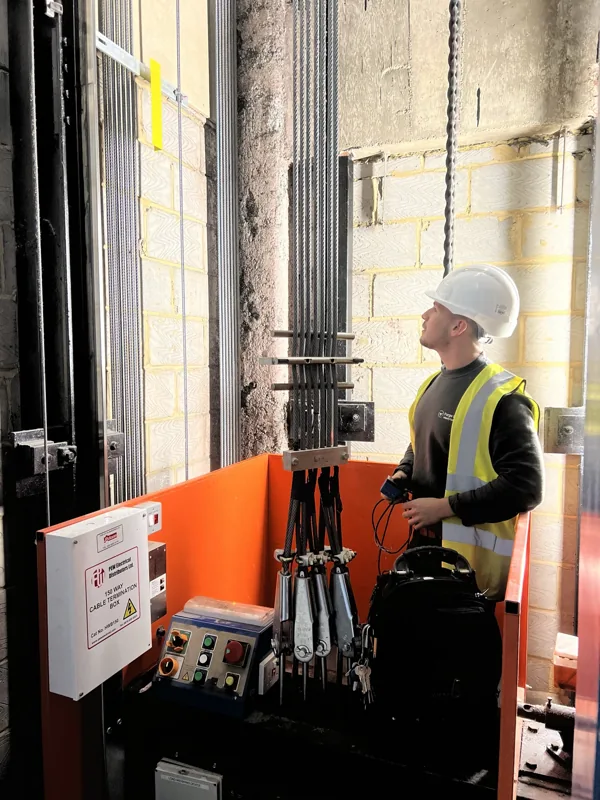 Forge Lifts engineer beside lift ropes and operating equipment