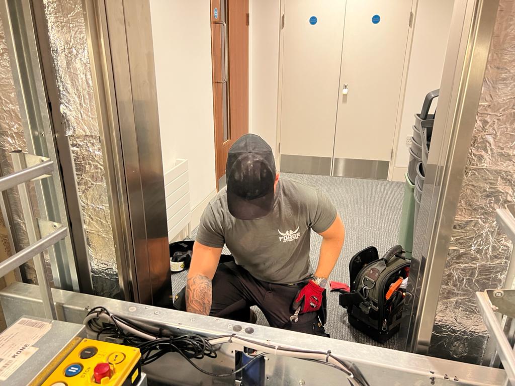 Lift engineer checking a lift door operator.